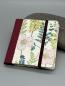 Preview: Haftnotizblock mit Stift Sommerblumen – Vorderdeckel mit buntem Blütenmotiv auf Graspapier, weinrotes Buchbinderleinen und Gummiband