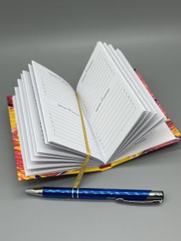 Preview: Immerwährender Taschenkalender Marmoriert – offen liegende Seiten mit Lesebändchen, Kapitalband und Stiftnder Taschenkalender – Seitenansicht mit Lesebändchen und Stift