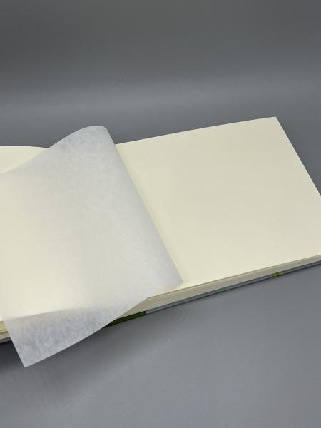Fotoalbum 15×21 cm quer Kleiner Prinz – aufgeschlagene Seite mit leinenstrukturiertem Pergaminblatt über weißem Fotokarton