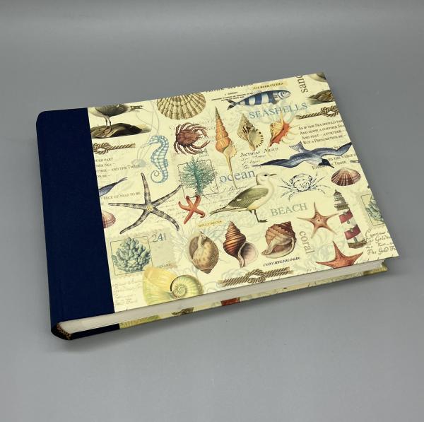 Fotoalbum 15×21 cm quer Marina – Vorderdeckel mit maritimem Golddruck-Motiv von Kartos (Muscheln, Seesterne), blauer Leinenrücken