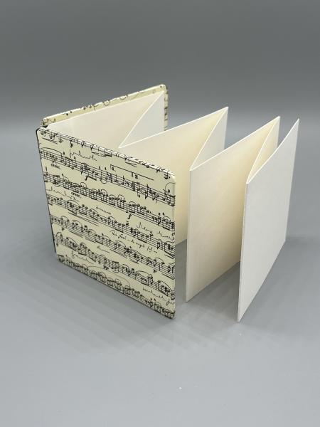Handgebundenes Leporello Partitur 10 – Faltbuch 10×10 cm mit Notenmotiv, schwarzer Leinenrücken, Satinband