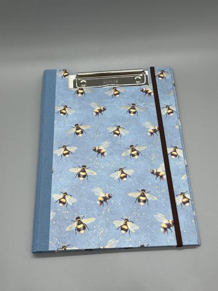 Handgebundene Klemm-Mappe A5 Bienen – Vorderdeckel mit Bienenmotiv und Golddruck von Kartos auf Blau, hellblauer Leinenrücken