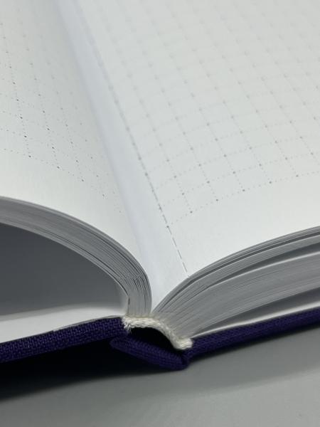 Notizbuch A4 Ganzband Marmorfenster lila – Detailansicht hochweise Seiten mit 5mm-Punktraster und Mikroperforation