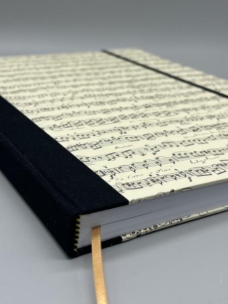 Notizbuch A4 Partitur – Detailansicht schwarzer Leinenrücken mit Lesebändchen und Kapitalband