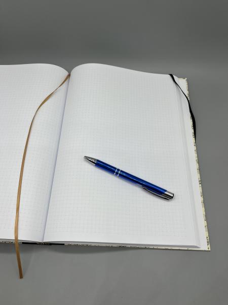 Notizbuch A4 Partitur – offen liegendes Buch mit punktkarierten Seiten und Lesebändchen