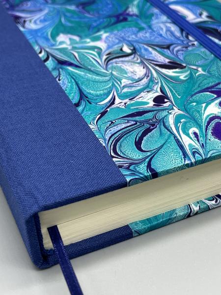 Notizbuch 17×12 cm Marmoriert – Detailansicht Leinenrücken mit Lesebändchen und Kapitalband