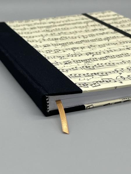 Notizbuch A5 Partitur punktkariert – Detailansicht Bindung, Lesebändchen und schwarzer Leinenrücken