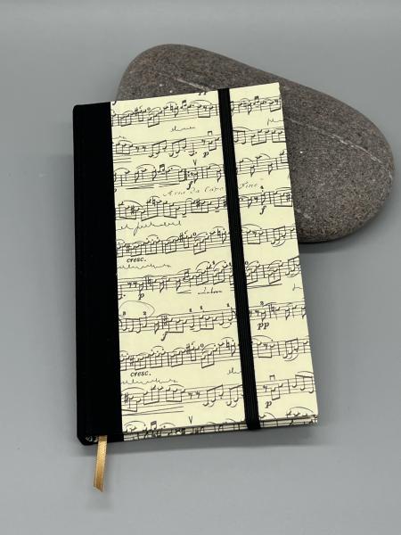 Notizbuch 9×15 cm Partitur – Vorderdeckel mit Notenmotiv und Goldpulverdruck von Kartos, schwarzer Leinenrücken, Gummiband
