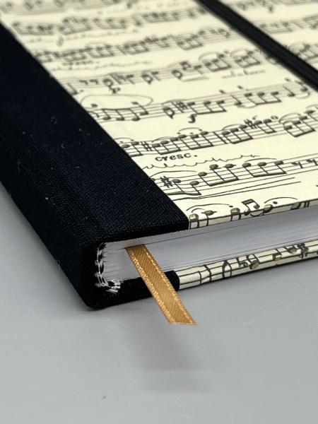 Notizbuch 9×15 cm Partitur – Detailansicht schwarzer Leinenrücken mit Lesebändchen und Kapitalband